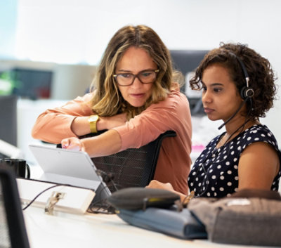 Two people checking something in a laptop