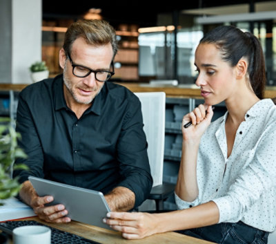 A man and a woman looking at a tablet.