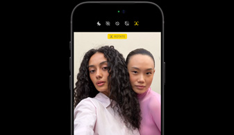iPhone 18 Pro in Black, front-facing, showcasing two people with face tracking feature, demonstrates the Centre stage front camera feature